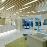 a lobby with a waiting area with a couch and chairs at Hesperia Murcia Centro