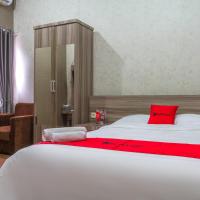 a bedroom with a large white bed with a red pillow at RedDoorz Plus near IPDN, Sumedang