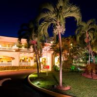 a large white building with palm trees in front of it at Terra Nova All Suite Hotel, Kingston