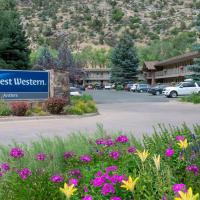 a sign for a hotel in a parking lot with flowers at Best Western Antlers, Glenwood Springs