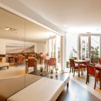 a restaurant with tables and chairs and a couch at Hotel Adagio, Knokke-Heist