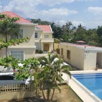 a villa with a swimming pool and a house at Beach Garden Hotel, Dili