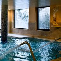 a large swimming pool in a building with a fountain at Rutllan & Spa, La Massana