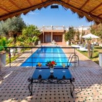 a swimming pool with a table in front of a house at Villa Ayche, Marrakesh
