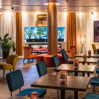 a lobby on a cruise ship with tables and chairs at Falkensteiner Hotel Bratislava