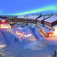 a lodge with a rainbow in the sky over a snow covered town at Hotel Hullu Poro, Levi
