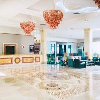 a lobby with blue chairs and chandeliers at Royal Thalassa Monastir