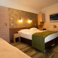 a hotel room with two beds and a table at Teátrum Boutique Hotel, Győr