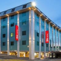 a large blue building with red signs on it at ibis Lausanne Centre