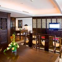 a living room with a table and chairs and a television at Crowne Plaza Qingdao, an IHG Hotel