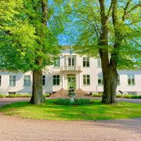 a white house with trees in front of it at Drottning Victorias Hotell & Vilohem, Borgholm