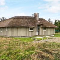an old house with a thatched roof on a field at Four-Bedroom Holiday home in Vejers Strand 9