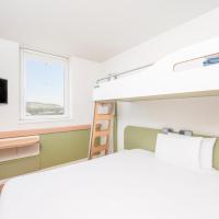 a bedroom with a bunk bed and a tv at ibis budget Bern Expo