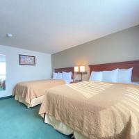 a hotel room with two beds and a window at Travelodge by Wyndham Great Falls