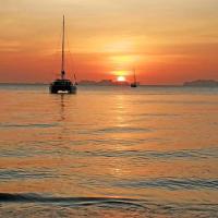 a sail boat in the water at sunset at Koh Jum Delight Beach, Ko Jum