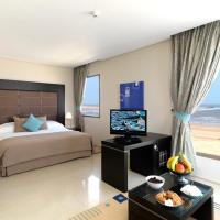 a bedroom with a bed and a television and a beach at Atlas Essaouira & Spa