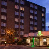 a hotel building with a green sign in front of it at Holiday Inn Portsmouth, an IHG Hotel