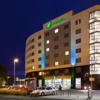 a hotel building with cars parked in a parking lot at Holiday Inn Norwich City, an IHG Hotel