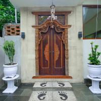 a front door of a house with two potted plants at Zamzam anjani villa, Praya