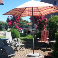 a patio with an umbrella and a chair at Haus Marianne, Schafstedt