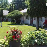 a yard with flowers and plants in front of a house at Colonial Resort-1000Islands, Gananoque