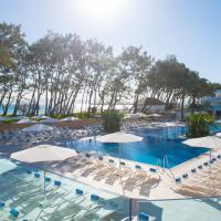a large swimming pool with chairs and umbrellas at Iberostar Playa de Muro