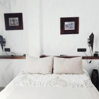 a bedroom with a bed with white sheets and pillows at Hospedería El Caravansar, Frigiliana