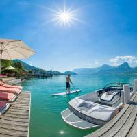 a person is standing on a paddle board on a dock at Hotel Furian, St. Wolfgang