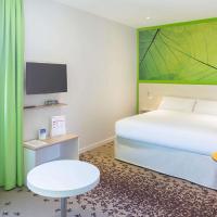 a bedroom with a white bed and a green wall at ibis styles Villeneuve Sur Lot, Villeneuve-sur-Lot
