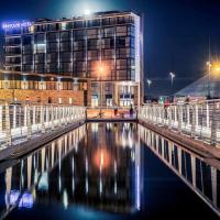 a building at night with a body of water at Mercure Cherbourg Centre Port, Cherbourg en Cotentin