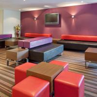 a waiting room with colorful furniture and a tv at Holiday Inn Express Poole, an IHG Hotel
