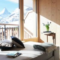 a bedroom with a bed with a view of a mountain at Carina - Design&Lifestyle hotel, Zermatt