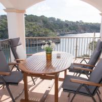 a table and chairs on a balcony with a view of the water at Apartamentos Vista al Puerto, Cala Figuera