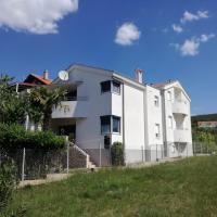 a white building on top of a grassy hill at Apartments Maleo, Sveti Petar
