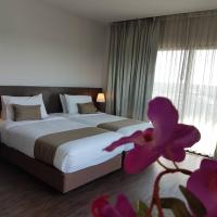 a bedroom with a large bed and a purple flower at Coco View Hotel, Samut Songkhram