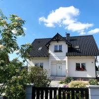 a white house with a black roof at E&S_ Apartament, Milicz