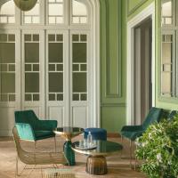 a living room with green walls and chairs and a table at Aristide Hotel, Ermoupoli