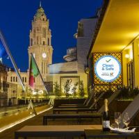a restaurant with tables and a clock tower at night at Pao de Acucar Hotel, Porto