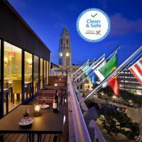 a restaurant with flags on a balcony with a clock tower at Vera Cruz Porto Downtown Hotel