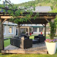 a pergola with couches and chairs in a yard at Le Castelet, Le Mont-Dore