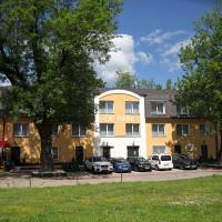a large yellow building with cars parked in a parking lot at Hotel CK Park, Český Krumlov