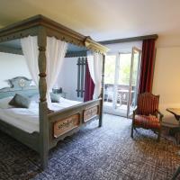 a bedroom with a canopy bed and a table with a lamp at Les Portes de la Vallee, Turckheim