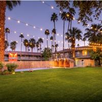 a house with a yard with palm trees and lights at Caliente Tropics, Palm Springs