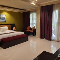 a bedroom with a bed and a couch in a room at Novo Turismo Resort & Spa, Dili