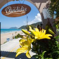 a yellow flower in front of a sign with a beach at Dandidis Seaside Pension, Agios Gordios