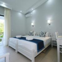 a white bedroom with a bed and a balcony at Ifestos Hotel, Myrina