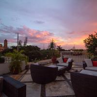 a patio with couches and a sunset in the background at Hotel Meson del Marques, Valladolid