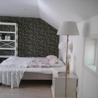 a bedroom with a bed and a lamp and a wall at Villa Kastu, Naantali