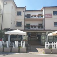 a building with white chairs and umbrellas in front of it at Hotel La Favorita, Peschiera del Garda