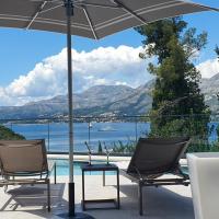 a patio with chairs and an umbrella next to a pool at Hotel Seventh, Cavtat